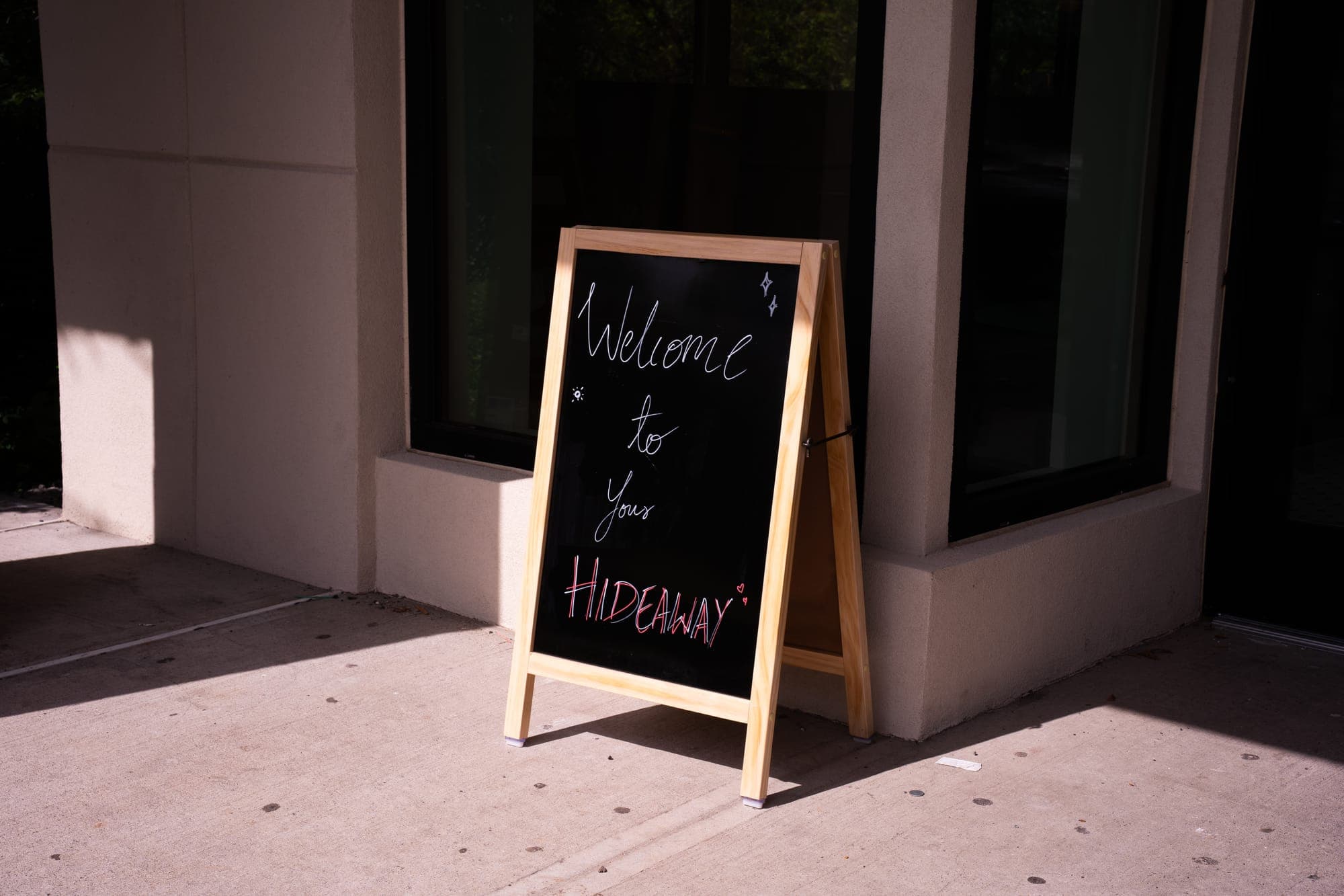 A chalkboard sign by the door that reads Welcome to your hideaway